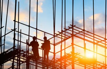 construction workers on the job at sunset